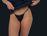 This image features a minimalist black G-string, designed to be barely visible under clothing. It is crafted from 100% cotton, emphasizing comfort and breathability.