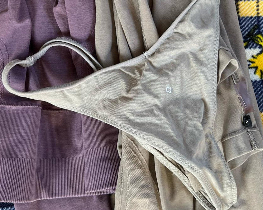 This image features a minimalist design, showcasing a pair of beige cotton thongs referred to as "Number 3 in Rain Cloud." The thong has a simple, elegant V-shape front which helps to flatter the figure by elongating the torso and accentuating the hips.